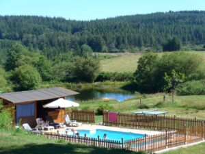 Vue sur la piscine chauffée et l'étang et son pédalo