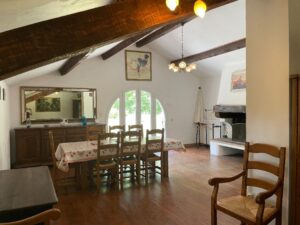 Le coin salle à manger avec sa cheminée ouverte et sa grande hauteur sous plafond.