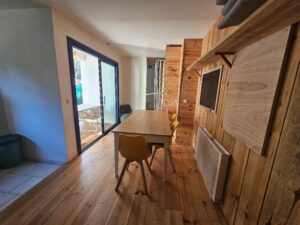 Séjour ouvert sur le jardin et la cuisine et avec un lit simple