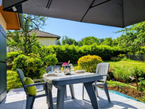 Champagne sur la terrasse ensoleillée à l'ombre du parasol en écoutant les oiseaux qui chantent